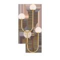 Highsmith Wall Sconce with three milk glass globes at varying heights on brass-finished metal stems and a travertine wall ...