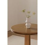 Close-up of tabletop with white ceramic vase holding delicate flowers on Charles Cafe Table in room setting