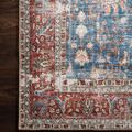 Top corner close-up of Loren Blue / Brick Rug on dark hardwood floor highlighting red and blue floral motifs
