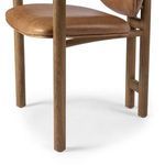 Angled side view highlighting smooth wooden armrest and textured caramel seat upholstery