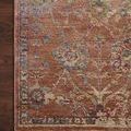 Close-up of the terracotta rug corner highlighting texture, floral patterns, and fringed edge