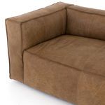 Close-up inset corner of sofa cushion and backrest highlighting soft leather and stitching detail.