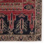 Close-up on corner of rug displaying detailed tribal motifs and intricate border