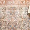 Close-up of Layla Ocean Rust Rug center pattern with an open book and decorative beads resting on it