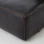 Detailed close-up of bottom corner seam featuring worn black leather and contrasting stitch trim