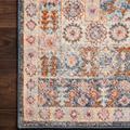 Close-up of rug corner showing intricate border pattern and pile texture on dark wood floor