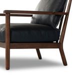 Wood armrest detail with smooth finish and leather seat cushion edge