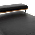 Close-up of seat cushion surface showing minimal stitching and sleek black leather finish