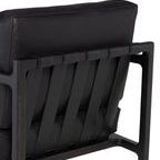 Close-up of the chair’s back showing leather straps and the wood frame’s texture and finish
