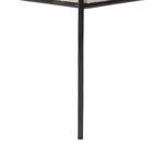 Close-up detail of slim hammered iron leg with textured black finish