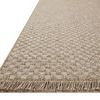 Side angled view showing textured checkered pattern and fringed edges of the rug