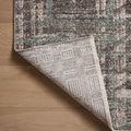 Rug corner flipped to display intricate backing pattern in neutral tones