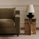 Close crop of Hutton sectional armrest next to a side table with black and white lamp