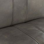 Close-up of grey leather upholstery showcasing fine decorative stitching and smooth finish