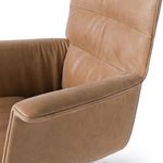 Close view of left armrest featuring smooth tan leather with stitched accents