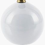Close-up of glossy white spherical ceramic base of the Ferez accent table lamp with brass neck