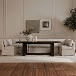 Full dining room setting showing U-shaped slipcovered banquette with dark wooden dining table and decorative vases