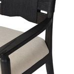 Close-up of armrest end and neutral woven seat cushion fabric on the Tova Dining Armchair