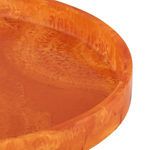 Close-up of orange resin tray edge highlighting marbled texture and glossy shine