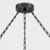 Top view of round black ceiling mount and three hanging metal chains supporting chandelier
