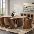 Dining room setting with Vander Wood Dining Table surrounded by eight upholstered chairs on textured rug