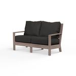 Laguna Loveseat outdoor sofa with hand-brushed aluminum frame mimicking driftwood and black seat and back cushions