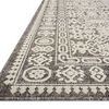 Close-up low-angle view highlighting the textured pile and detailed border pattern of the ivory rug