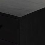 Close-up of smooth black wood corner detailing with subtle wood grain visible
