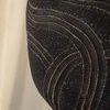 Zoomed close-up on the sculptural ceramic base showing carved wavy etchings and granular texture