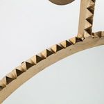 Close-up of textured, carved aged gold frame edge detailing surrounding the mirror