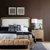 Bedroom setting with bed styled with black and white bedding, wood nightstand, and wall art