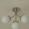 Straight-on bottom view focusing on round metal canopy and three frosted glass globes