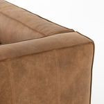 Detailed view of sofa’s left back corner showing rounded edge and leather stitching