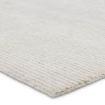 Close-up of ivory rug corner showing plush textured cut and looped pile with horizontal stripe detail