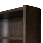 Close-up on rounded side corner of Lockhart Bookcase showing rubbed black finish and oak grain