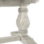 Detailed view of the pedestal base’s curved silhouette and carved horizontal banding