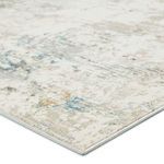Close-up of Jehan rug corner showing low pile texture and detailed abstract pattern with blue and gold accents