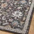 Angled view of rug corner on wood flooring showcasing intricate traditional pattern and charcoal color base