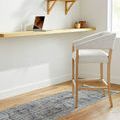 Blue-gray runner rug displayed under a light wood desk with chair, showing room context and scale