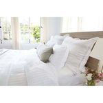 Bed styled with Blake duvet and coordinating pillow shams against rustic wooden wall