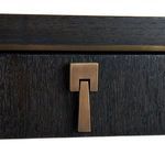 Detailed view of the bronze rectangular drawer handle on black oak grain texture