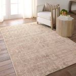 Rug styled in a bright living room with white armchair, wood floors, and a small side table with decor