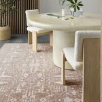 Taupe and cream rug under circular dining table viewed from side with chairs and gray flooring