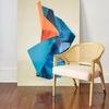 Edward Lounge Chair staged indoors on wooden floor against abstract blue and orange artwork