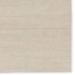 Close-up detail of rectangular rug surface highlighting fine woven construction and uniform cream color