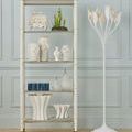 Decorative white vases with floral relief shown on white open shelving unit with accents