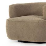 Angled close-up of front base and rounded armrest with swivel base peeking