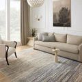 Soho Earth rug styled in a living room under a beige sofa and armchair with wall art and natural light