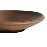side view showing the plate's slight lip and matte textured finish with natural color variations