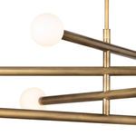 Side angle focusing on two white globe bulbs and the overlapping brass arm structure
